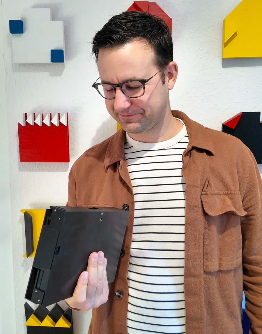 Florian holding the folded teleprompter, which is about the size of a thick book.
